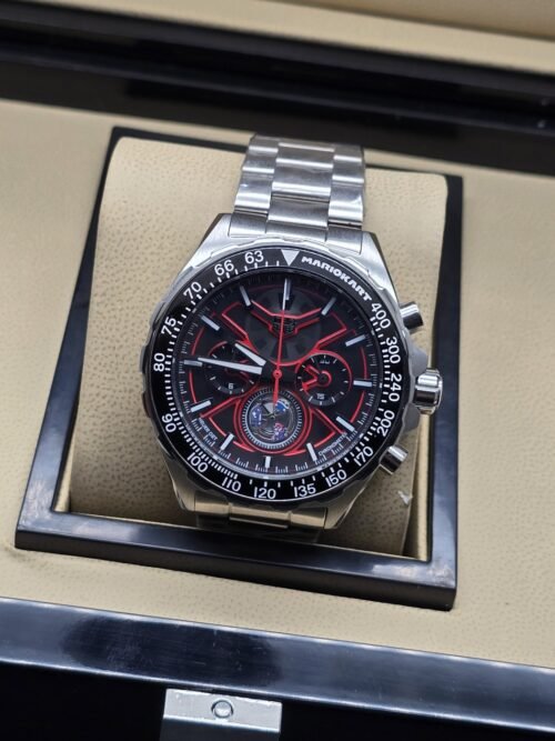 TAG Heuer — esfera negra con detalles rojos y brazalete plateado