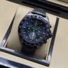 TAG Heuer — esfera oscura con detalles verdes y correa negra