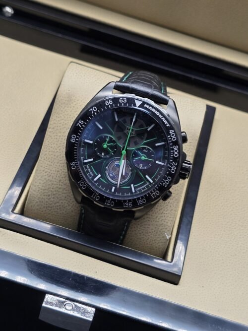 TAG Heuer — esfera oscura con detalles verdes y correa negra