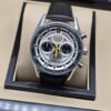 TAG Heuer — esfera plateada con detalles amarillos y correa negra