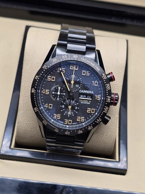 TAG Heuer — esfera oscura con números dorados y brazalete negro