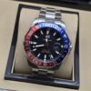 TAG Heuer — esfera negra con bisel rojo y azul y brazalete plateado
