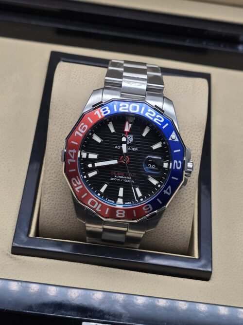 TAG Heuer — esfera negra con bisel rojo y azul y brazalete plateado