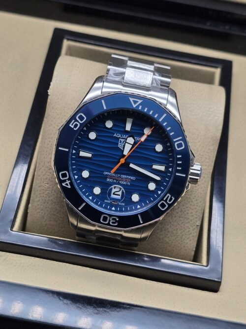 TAG Heuer — esfera azul con aguja naranja y brazalete plateado