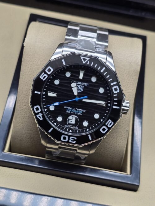 TAG Heuer — esfera negra con aguja azul y brazalete plateado