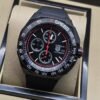 TAG Heuer — esfera negra con detalles rojos y correa negra
