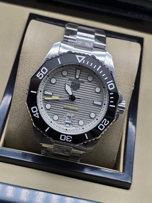 TAG Heuer — esfera clara texturizada con bisel negro y brazalete plateado