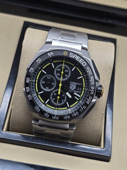TAG Heuer — esfera negra con detalles amarillos y brazalete plateado
