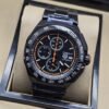 TAG Heuer — esfera negra con detalles naranjas y brazalete negro