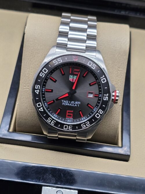 TAG Heuer — esfera gris con detalles rojos y brazalete plateado