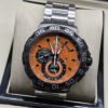 TAG Heuer — esfera naranja con subesferas negras y brazalete plateado