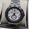 TAG Heuer — esfera blanca con detalles rojos y brazalete plateado