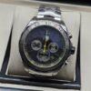 TAG Heuer — esfera negra con detalles amarillos y brazalete plateado