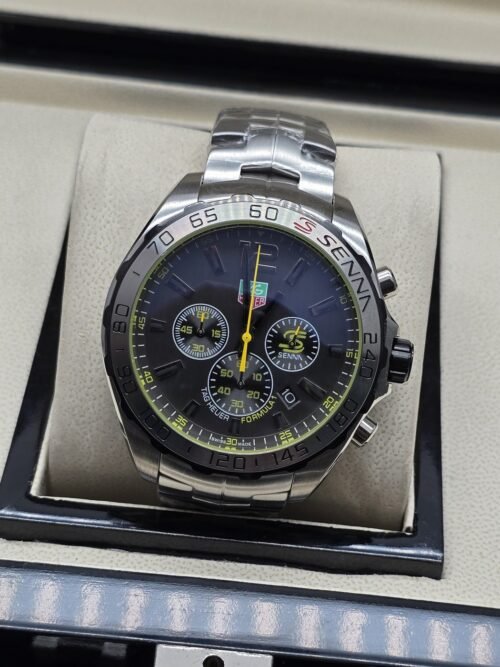 TAG Heuer — esfera negra con detalles amarillos y brazalete plateado