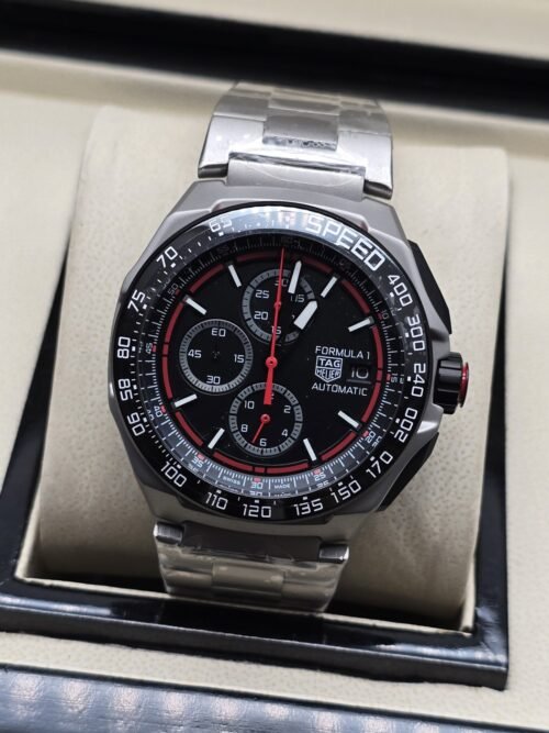 TAG Heuer — esfera negra con detalles rojos y brazalete plateado