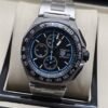 TAG Heuer — esfera negra con detalles azules y brazalete plateado