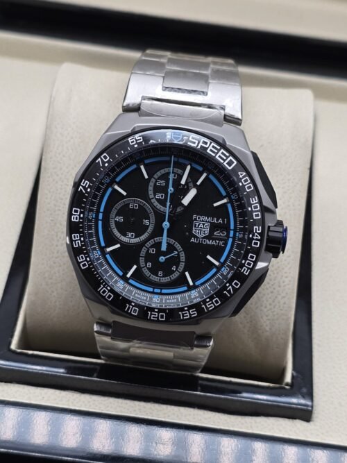 TAG Heuer — esfera negra con detalles azules y brazalete plateado