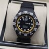 TAG Heuer — esfera negra con aro amarillo y correa negra