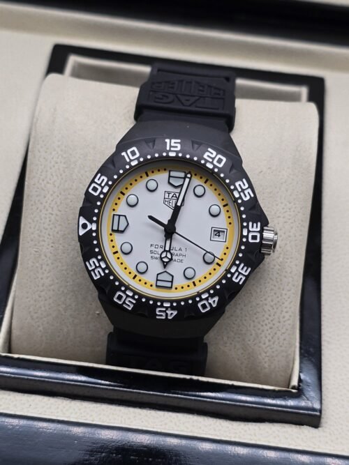 TAG Heuer — esfera blanca con aro amarillo y correa negra