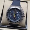 TAG Heuer — esfera oscura con aguja amarilla y correa azul