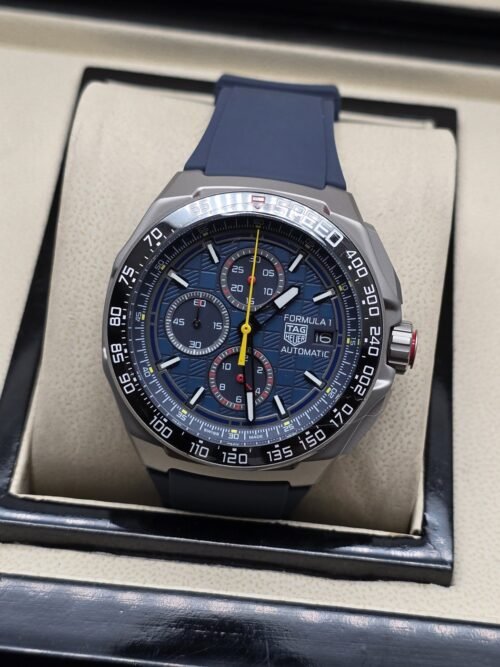 TAG Heuer — esfera oscura con aguja amarilla y correa azul