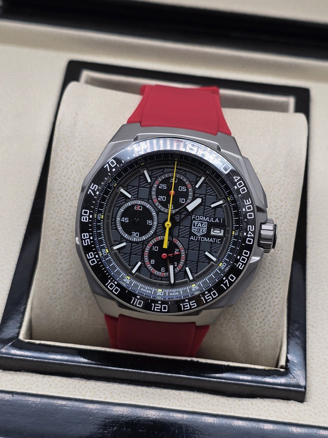 TAG Heuer — esfera negra con aguja amarilla y correa roja