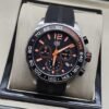 TAG Heuer — esfera negra con agujas naranjas y correa negra