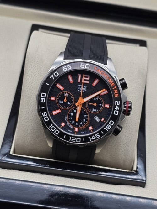 TAG Heuer — esfera negra con agujas naranjas y correa negra