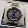 TAG Heuer — esfera negra con bisel dorado y brazalete bicolor