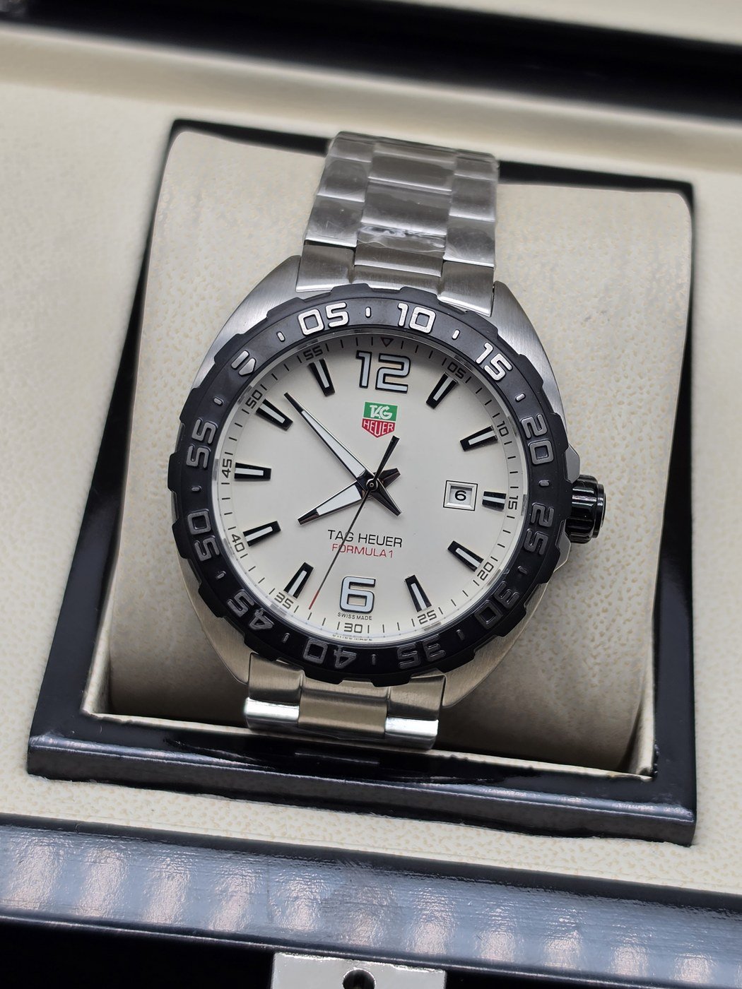TAG Heuer — esfera blanca con números y brazalete plateado