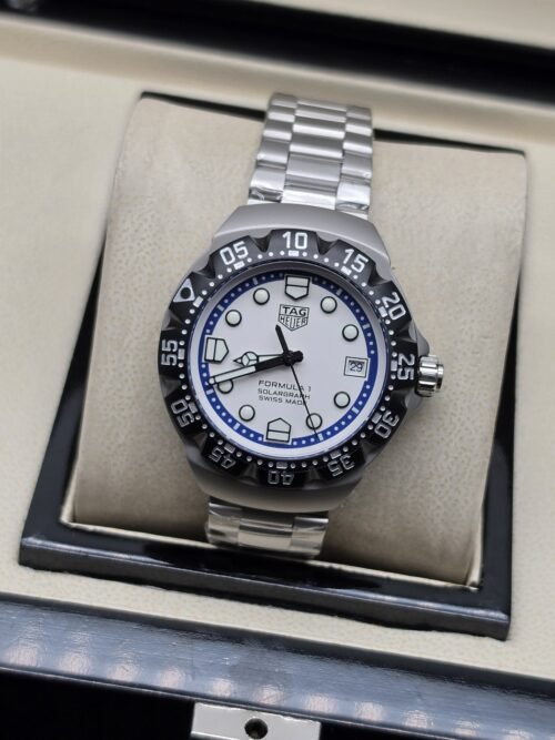 TAG Heuer — esfera blanca con aro azul y brazalete plateado