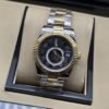 Rolex — esfera negra con subesfera, bisel dorado estriado y brazalete bicolor