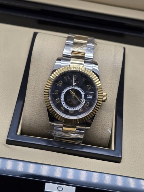 Rolex — esfera negra con subesfera, bisel dorado estriado y brazalete bicolor