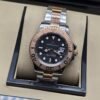 Rolex — esfera negra con bisel rosado y brazalete bicolor