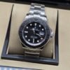 Rolex — esfera negra y bisel oscuro con brazalete plateado