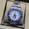 Rolex — esfera blanca con bisel azul y brazalete plateado
