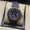Rolex — esfera negra con bisel negro, caja dorada y correa negra