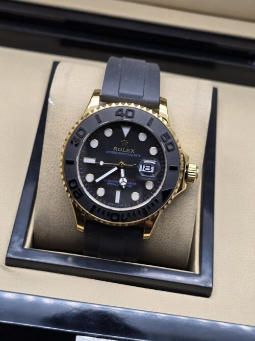 Rolex — esfera negra con bisel negro, caja dorada y correa negra