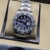 Rolex — esfera con patrón blanco y negro, bisel negro y brazalete plateado