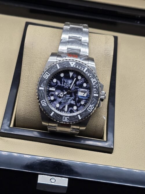 Rolex — esfera con patrón blanco y negro, bisel negro y brazalete plateado