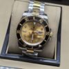 Rolex — esfera dorada con bisel negro y brazalete bicolor