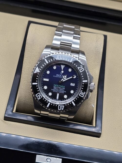 Rolex — esfera azul con bisel negro y brazalete plateado