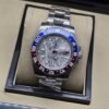Rolex — esfera gris texturizada con bisel rojo y azul, brazalete plateado
