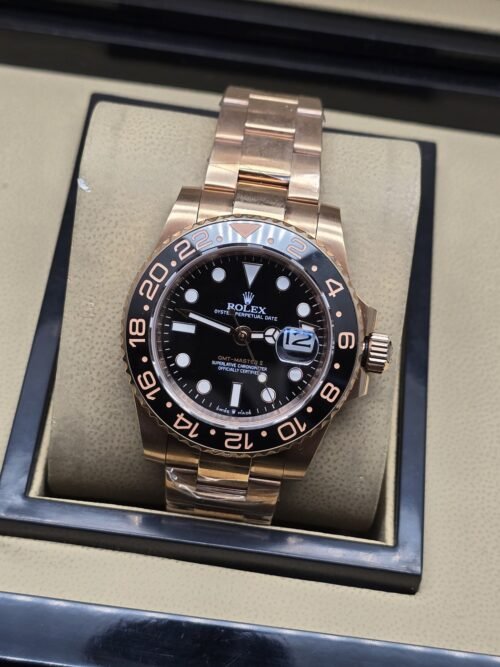 Rolex — esfera negra con bisel negro y rosado, brazalete rosado