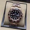 Rolex — esfera oscura con bisel negro y rosado, brazalete rosado