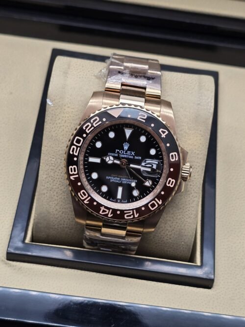 Rolex — esfera oscura con bisel negro y rosado, brazalete rosado