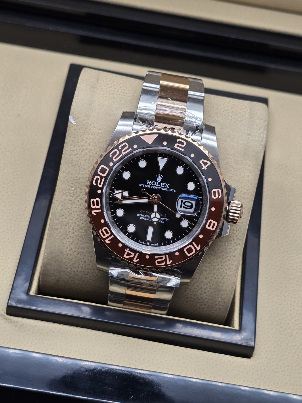 Rolex — esfera negra con bisel rosado y brazalete bicolor