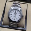 Rolex — esfera blanca con números 3, 6 y 9, brazalete plateado