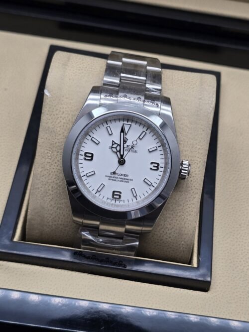 Rolex — esfera blanca con números 3, 6 y 9, brazalete plateado