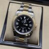 Rolex — esfera negra con números 3, 6 y 9, brazalete bicolor
